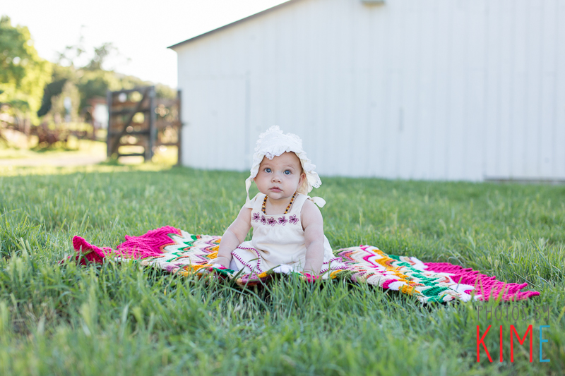 baby girl sitting in grass pose