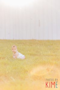 baby girl in the grass posing