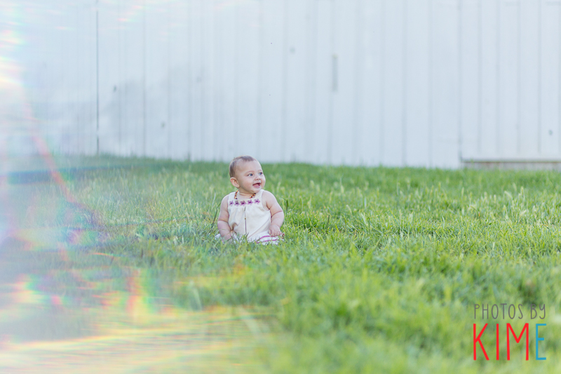baby girl sitting in grass pose