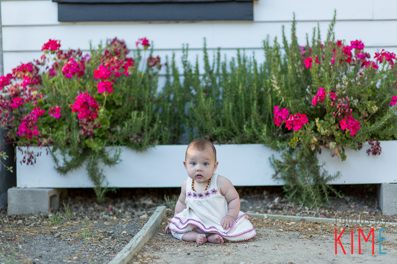 baby girl sitting with flowers pose