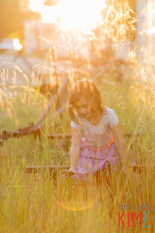 girl playing in the grass during sunset