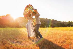 photos by kim e - san jose photographer - family session at rancho san antonio - sunset - rustic - family session - golden hour - parachute - kissing - family of three posing