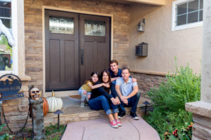 Family of four in front of their house