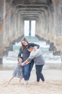 family of three under the manhattan beach pier