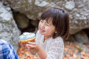 Girl eating a donut with a smile