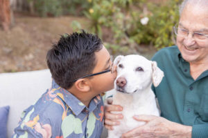boy giving kisses to the family dog for their family pet photos sessoin