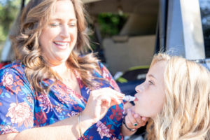 mom putting lipstick on her daughter before her family photos at stanford cactus garden