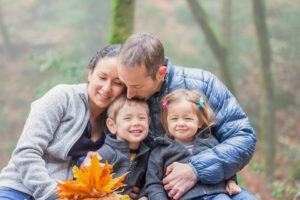 family of four with fall leaves for fall family photos