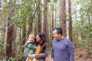 family of three in forest for fall family photos