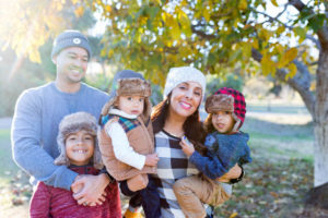 family of five dressed up for winter under a fall tree