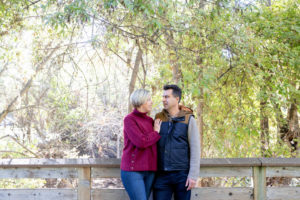 fall portraits at vasona park with two people on a bridge looking at each other