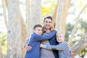 fall portraits at vasona park with dad being hugged by his two sons