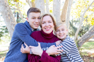 fall portraits at vasona park with mom getting hugs from her two boys