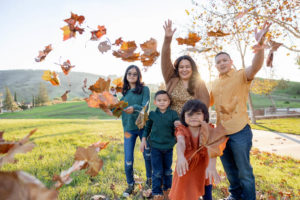 family photography san jose session with family of five throwing leaves in the air
