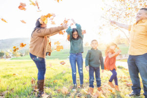 family photography san jose session with family of five throwing leaves in the air