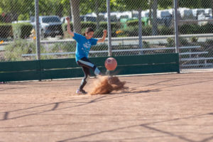 player kicking a red kickball