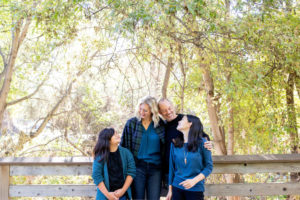 photos at vasona park with family of four standing on a bridge looking at each other