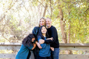 photos at vasona park with family of four on a bridge, kids tackling the parents