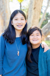 photos at vasona park with portrait of two sisters wearing blue and looking at the camera