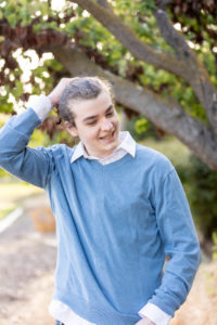 san jose portrait photography session of a young man in a blue sweater adjusting his hair