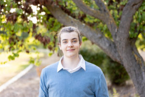 san jose portrait photography session of a young man wearing blue sweater under a tree