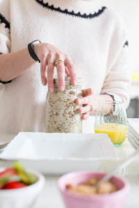 woman's hands closing a mason jar of overnight oats