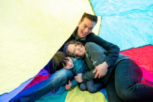 family of three in a giant parachute