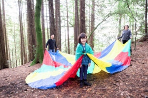 girl wearing a giant parachute as a cape