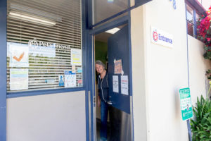 woman opening up the front door of a vet office for business branding photos