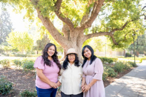 mom with her two daughters in front of a tree for extended family photos
