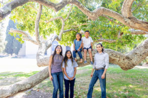 grandchildren extended family photo next to giant tree limbs