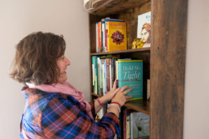 therapist putting books up on a book shelf