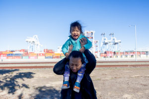 family photos in oakland with family of three in middle harbor shoreline park