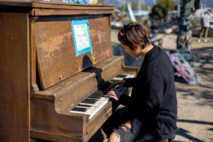 girl playing on a piano at adventure playground in berkeley