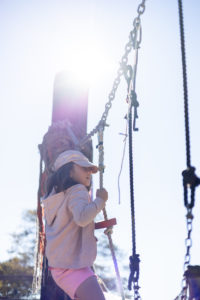 girl climbing on ropes at adventure playground in berkeley
