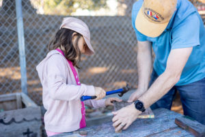 father and daughter building a chair at adventure playground in berkeley