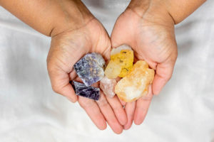 woman holding five crystals in her hands