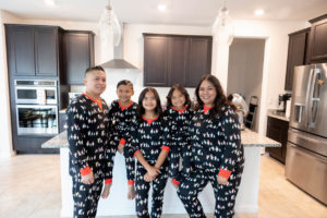 family of five wearing penguin pajamas in the kitchen for their family holiday traditions session