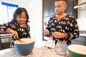 dad and daughter baking cookies in the kitchen
