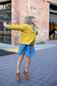little girl jumping wtih joy after having ice cream