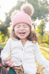 little girl smiling with a pink hat and fuzzy ears