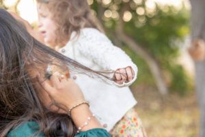 little girl pulling mom's hair