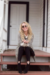 fashion lifestyle san jose blogger sitting on a red porch wearing sunglasses