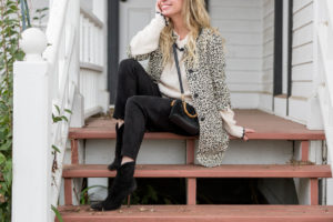 fashion blogger sitting on a red porch