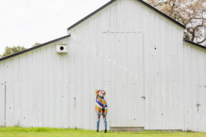 fashion lifestyle san jose blogger standing in front of a white barn