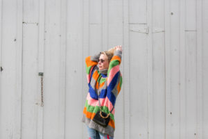 fashion blogger wearing a bright striped sweater