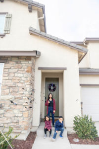 siblings standing in front of their new home for their new neighborhood family photos
