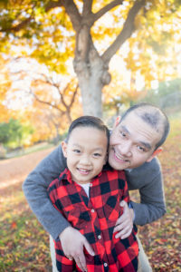 outdoor fall family photos with dad and son portrait under fall colored leaves