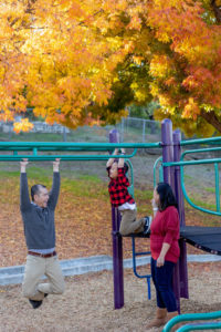family of three playing on a playground for their outdoor fall family photos in san jose