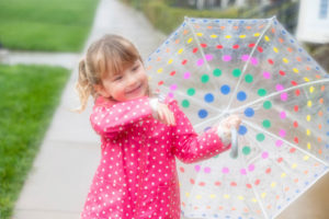 little girl holding a polkadot umbrella in the rain at crissy fields in san francisco
